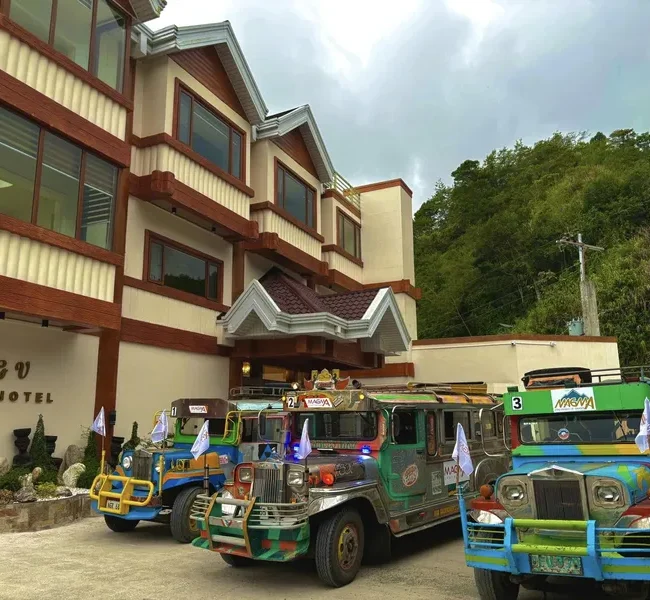 Facade of Banaue Grandview Hotel with the BGV Hotel sign and jeepneys parked in front