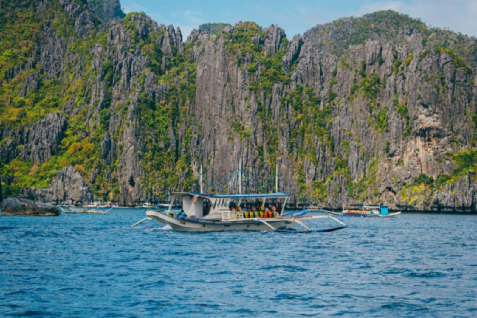 A traditional boat below limestone cliffs in El Nido, Palawan
