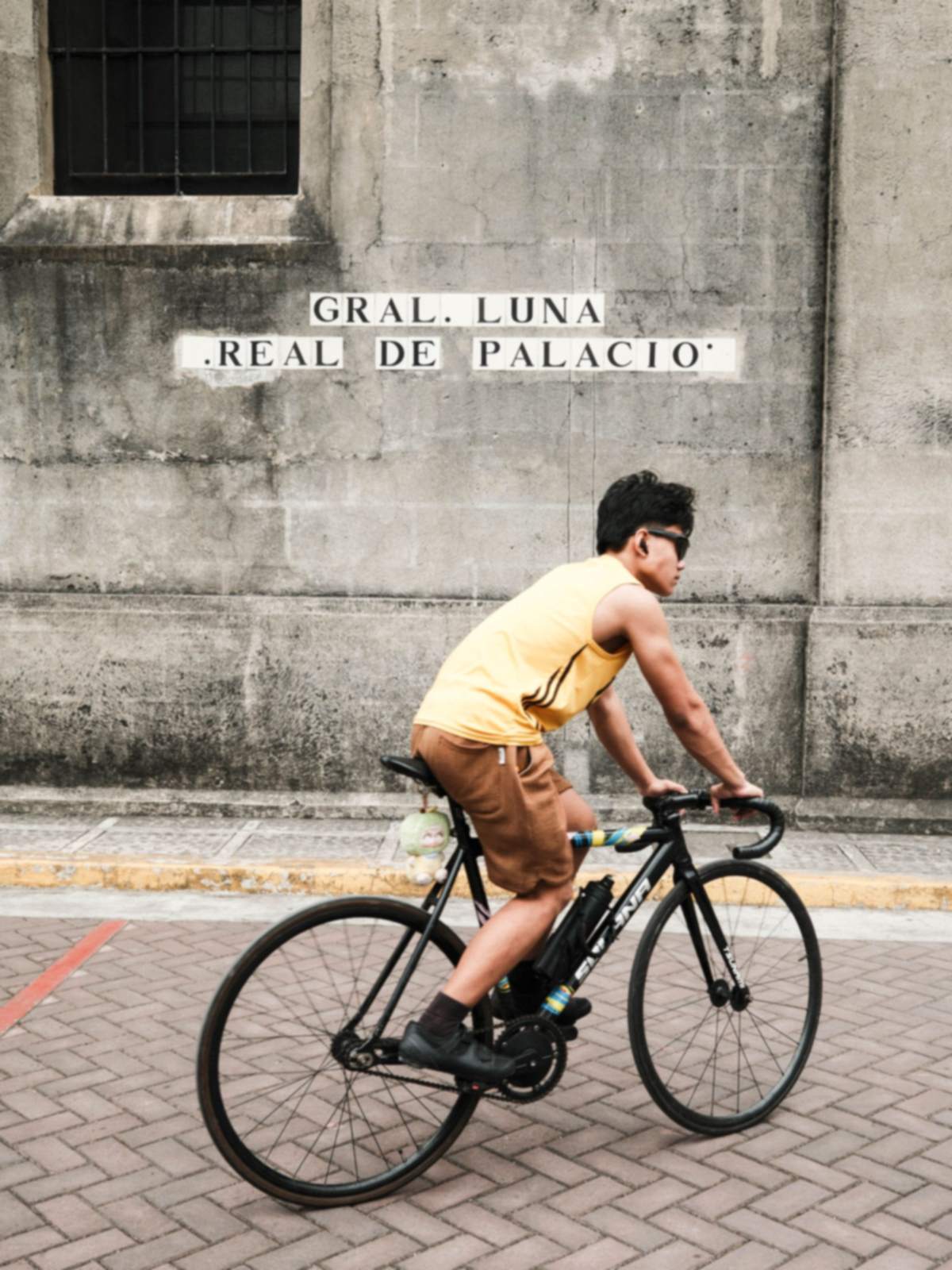 A cyclist passing the old walls of Intramuros, Manila