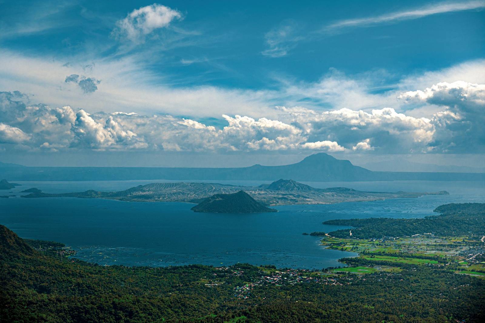 Taal Lake and Taal Volcano seen from Tagaytay under a blue sky